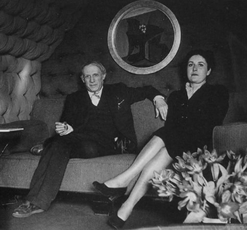 Пабло и Дора сидят под одной из его картин, 1940-е