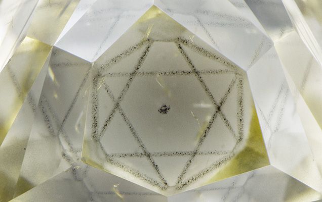 Рисунок огранки этого алмаза включает четыре шестиугольные грани, образующие окно включения октаэдрической формы. Под этим углом зрения октаэдр напоминает шестиконечную звезду. Микрофотография Натана Ренфро; поле зрения 4,69 мм