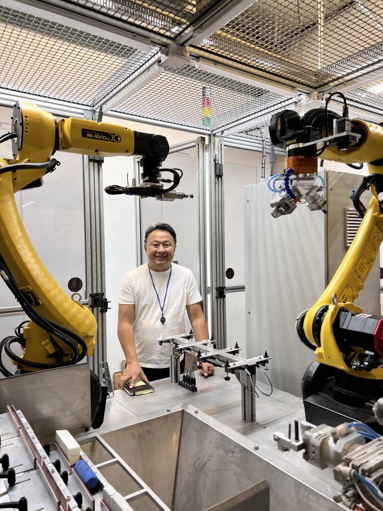 Кристиан Це позирует с новой роботизированной системой полировки на своем ювелирном предприятии