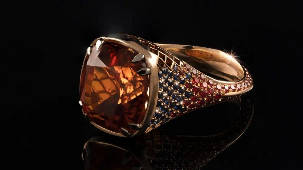 Кольцо Apollo с граненым мандариновым гранатом огранки кушон весом 10,55 карата и 188 оранжевыми и синими сапфирами Кольцо Apollo с граненым мандариновым гранатом огранки кушон весом 10,55 карата и 188 оранжевыми и синими сапфирами