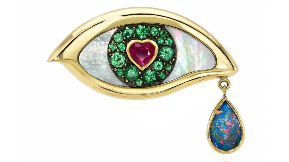 Брошь Lover’s Eye из 18-каратного золота, символизирующая горько-сладкую уязвимость зарождающейся любви, украшена рубиновым сердцем, окруженным радужной оболочкой из зеленых изумрудов, в перламутровой инкрустации. Опаловая слеза свисает с уголка глаза 