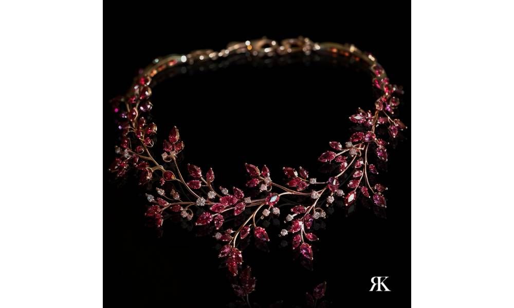 Роскошное ожерелье Ruby Floral Radiance с нежными виноградными лозами, украшенными рубинами. Каждый драгоценный камень искусно оправлен в теплое розовое золото, позволяя насыщенным красным тонам мерцать при каждом движении. Дополненное ослепительными бриллиантами, устроившимися среди ветвей виноградной лозы, это изделие излучает изысканность 