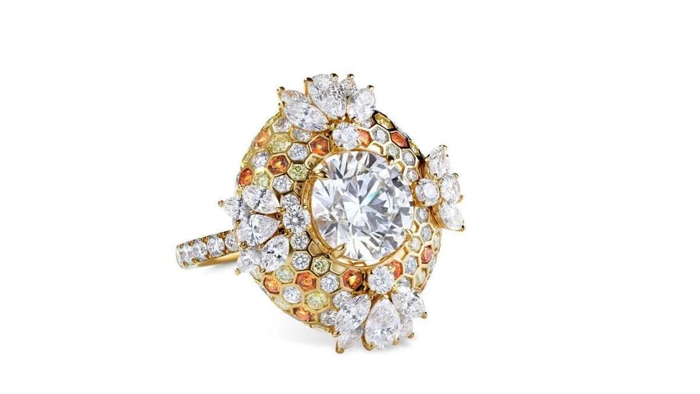 Кольцо, которое Сид Уилсон одобрил для своей возлюбленной Келли, украшено белым бриллиантом весом 2,5 карата, обрамленным золотыми сотами и белыми бриллиантовыми пчелами — отсылка к нежному прозвищу звезды. Изображение: Mouawad