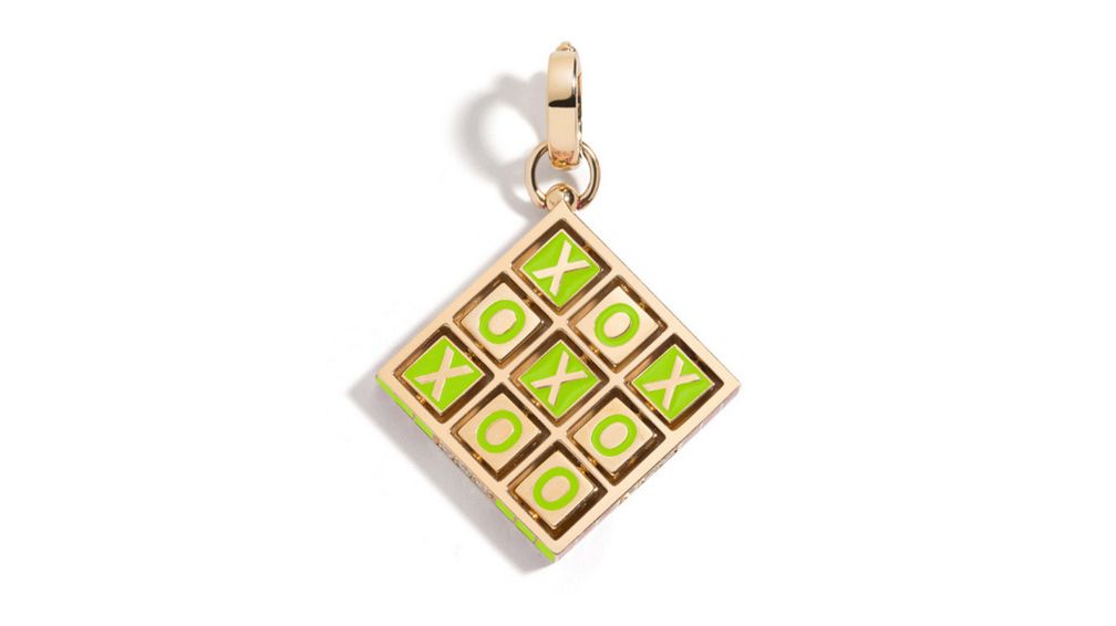 Подвеска XOXO представляет собой игровое поле для игры в крестики-нолики из 14-каратного желтого золота с эмалью Glowing Green и вращающимися плитками, изображающими «X» и «O» 