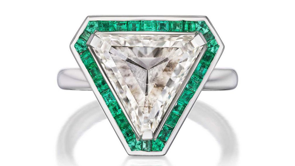 Коктейльное кольцо геометрической формы эпохи ар-деко с бриллиантом огранки триллион весом 4,40 карата, дополненным изумрудами квадратной и фантазийной огранки общим весом 0,60 карата в платиновой оправе