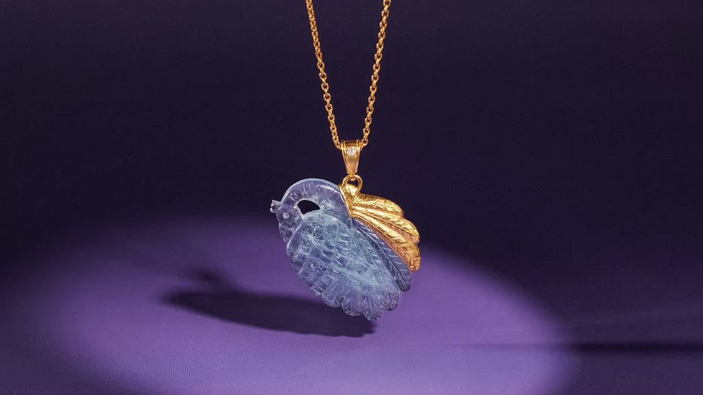 Павлин, вырезанный из аквамарина, украшен 24-каратным желтым золотом и прикреплен к цепочке из 22-каратного желтого золота с помощью кольца из 18-каратного желтого золота с бриллиантом классической огранки
