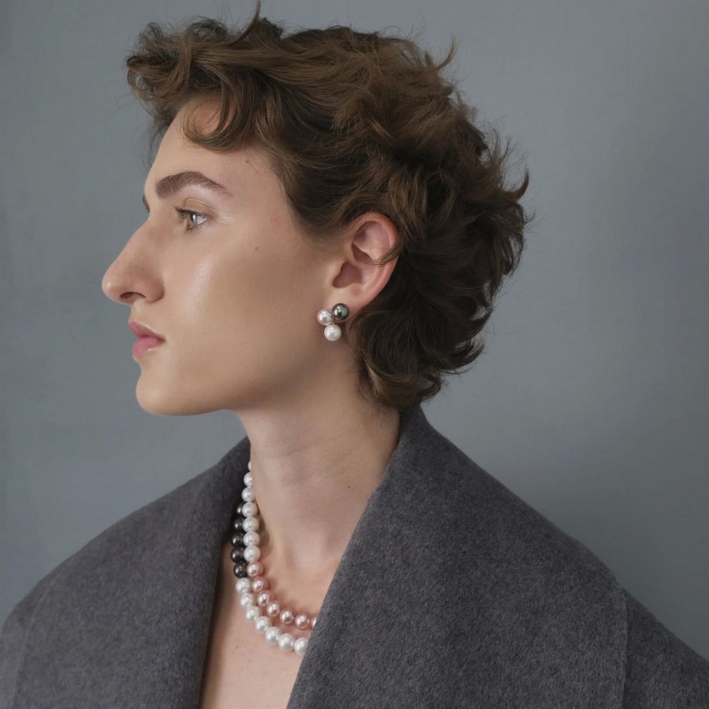 Серьги-гвоздики Tria, представленные здесь с лавандовым и белым жемчугом, доступны в других цветовых сочетаниях; на модели также представлено двухрядное ожерелье с черным таитянским жемчугом в 18-каратном желтом золоте