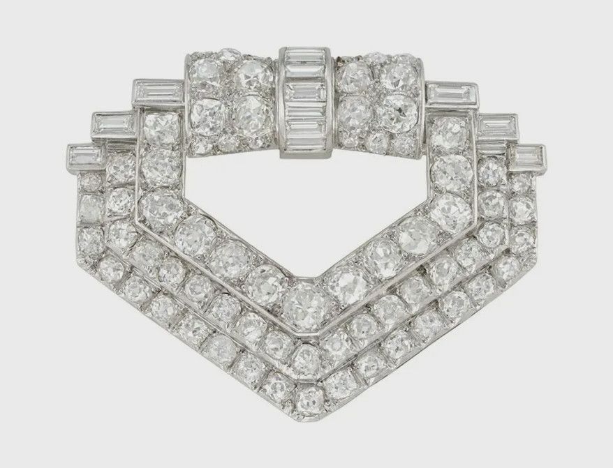 Леди Мэри носит на спине своего красного платья эту архитектурную брошь с бриллиантами багетной и старой европейской огранки в геометрической платиновой оправе с двойной булавкой из белого золота. Фото: Bentley & Skinner