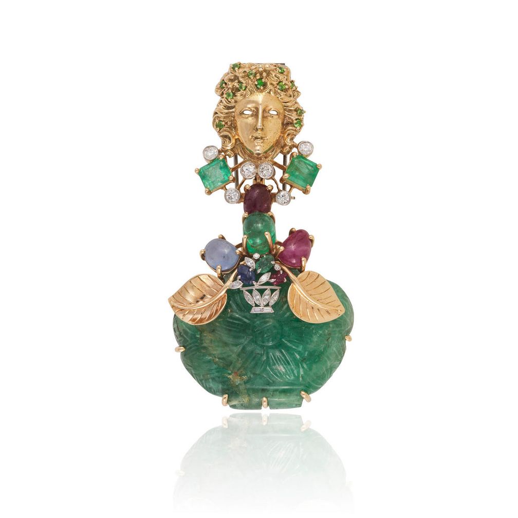 Брошь-часы от Seaman Schepps из 14-каратного желтого золота с гранатами, изумрудами, сапфирами, рубинами и бриллиантами. Резной изумруд огранки кабошон скрывает круглый циферблат с арабскими цифрами. Оценка: 9300–14 000 долларов США Брошь-часы от Seaman Schepps из 14-каратного желтого золота с гранатами, изумрудами, сапфирами, рубинами и бриллиантами. Резной изумруд огранки кабошон скрывает круглый циферблат с арабскими цифрами. Оценка: 9300–14 000 долларов США