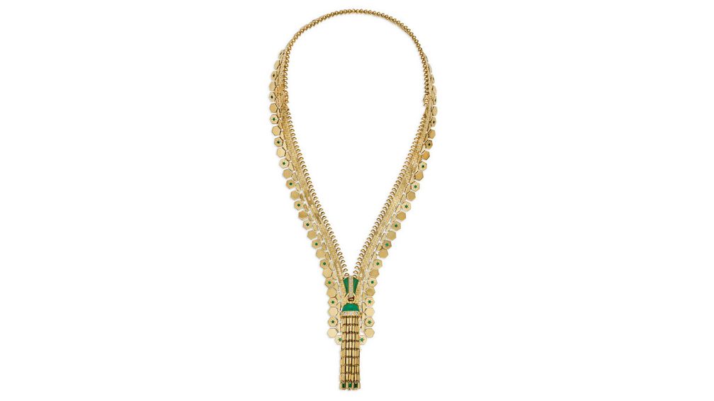 Колье Ludo Hexagone Zip от Van Cleef & Arpels из 18-каратного желтого золота, выполненное в виде застежки-молнии с кисточкой, украшено овальными кабошонами, пластинами хризопраза различной формы, изумрудами багетной и круглой огранки, а также бриллиантами круглой огранки