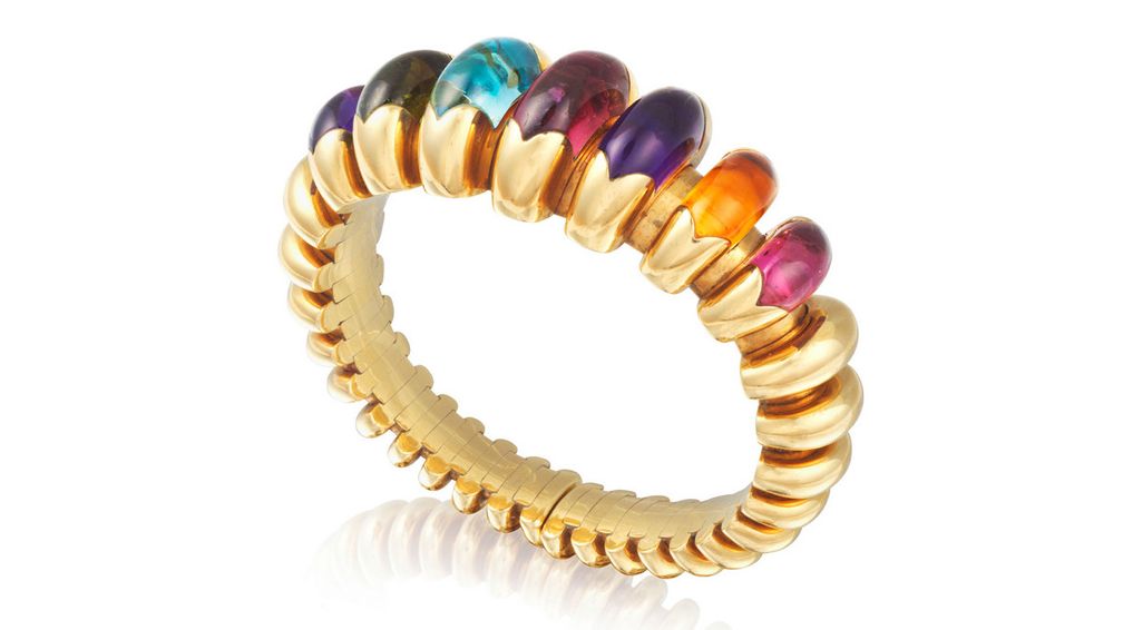 Браслет от Bulgari, выполненный в виде рифленого мотива из желтого золота, украшен розовыми и зелеными турмалинами, аметистами, голубыми топазами и цитринами огранки кабошон