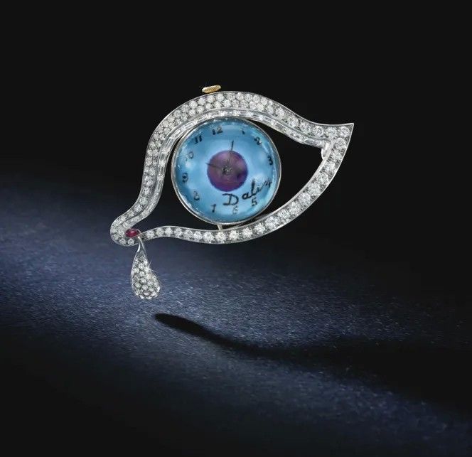 Часы-брошь «Глаз времени». Изготовлены из платины с бриллиантами, рубинами и синей эмалью. Дизайн Сальвадора Дали, изготовлено компанией Alemany and Ertman